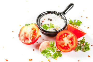 Food preparation background. Isolate. Spices and ingredients for cooking. Fresh tomatoes, whole and sliced, parsley, seasoning, spices, salt, garlic. Copy space