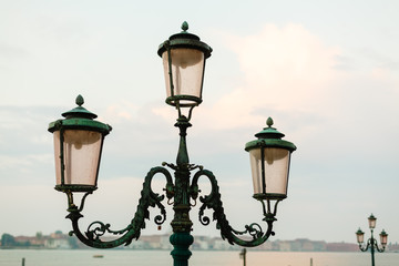 Fototapeta na wymiar glowing street lamp on mediterranean sunset