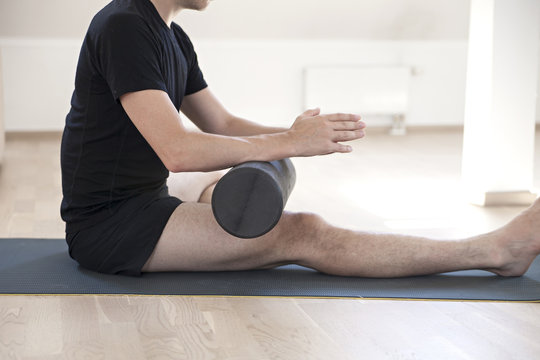 Man using roller on thigh