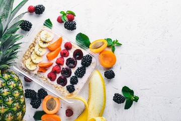 Oatmeal with fresh berries and fruits. Healthy Diet Food. Lunch Boxing. On a wooden background. Top view. Free space for text.