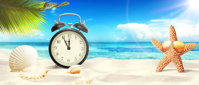 Sch&ouml;ner Strand mit Wecker - Urlaub Konzept