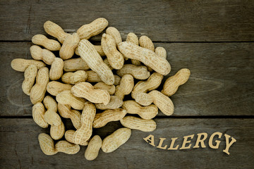 Peanut or groundnut food allergy health concept, close up on wooden background