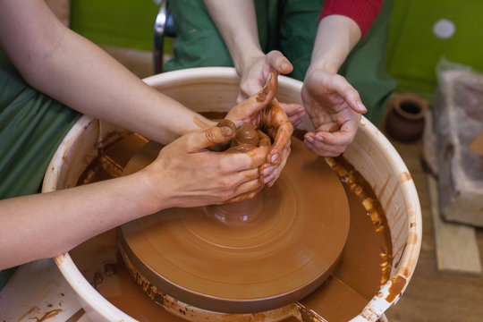The master teaches the student of ceramics. Work in the pottery workshop. The Potter's wheel in operation. Pottery school. The manufacture of ceramic products.