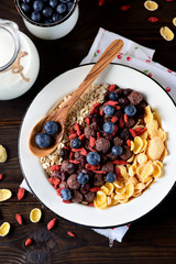 Healthy breakfast of cornflakes, chocolate balls, oatmeal, goji berries and fresh blueberries.