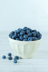 Blueberry in an white bowl on wooden table