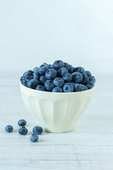 Blueberry in an white bowl on wooden table