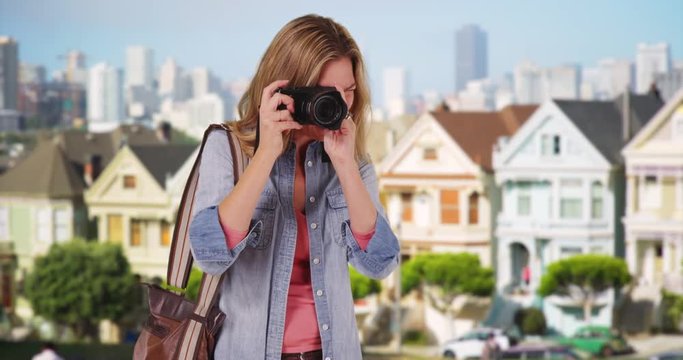 Female tourist or photographer taking photo of person on San Francisco street