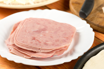 Sliced ham on the plate on the wooden table