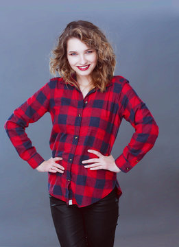 Young woman standing, isolated on gray background.