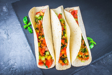 Traditional Mexican tacos with meat and vegetables on wooden background