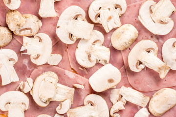 Flat lay above raw mushrooms on the pizza ham