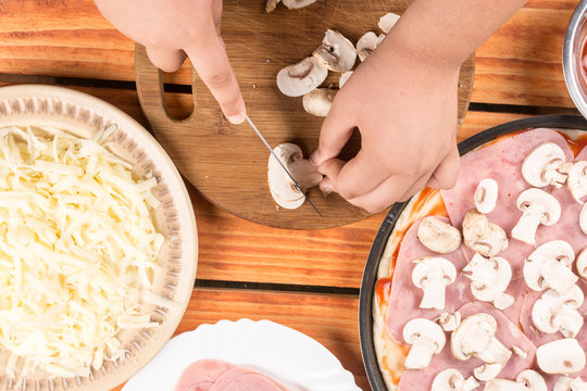 Slicing mushrooms and preparing ingredients for baking pizza