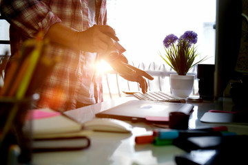 Young designer drawing sketches on graphic tablet. Creative professional designer's desk with...