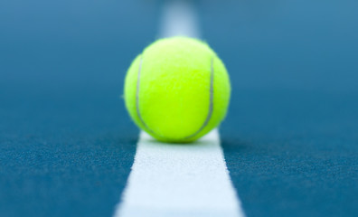 Tennis ball on tennis court with white line