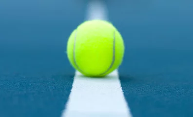 Fotobehang Tennis ball on tennis court with white line © Dmytro Flisak