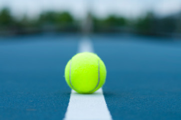 Tennis ball on tennis court with white line