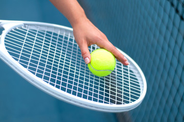 Tennis racket. Player holding tennis ball in hand  on the tennis court