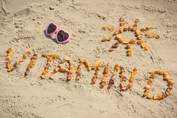 Inscription vitamin D with shape of sun and sunglasses at beach, summer time and healthy lifestyle...