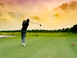 Poster Lady golfer, meisjesgolfspeler sloeg de golfbal met volle zwaai, volg de tee bij zonsopgang prachtige golfbaan © Wanmongkhol