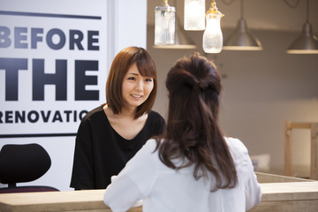 Women are talking at reception desk
