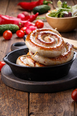 Spiral sausages in a small cast-iron frying pan