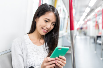 Woman use of cellphone and taking MTR in Hong Kong