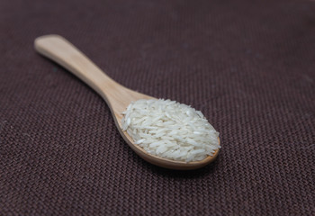 raw rice in wooden spoon