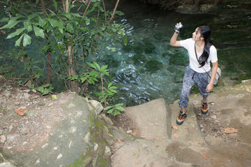 Asian woman taking photos in autumn forest