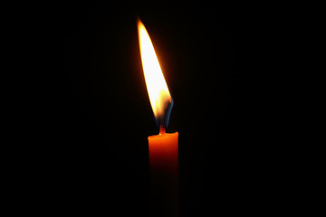 burning candle and light in dark