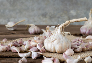 a Big garlic among seed garlic on old wooden table with big garlic background