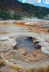 Hot Spring Geyser steaming in Black Sand Basin in Yellowstone National Park in Wyoming United States