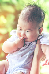 Closeup asian girl smiling happily with bright sunlight. Vintage effect tone.