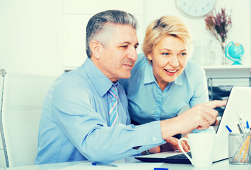 Old man with granddaughter are reading books