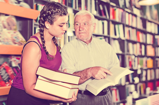 Joyful grandfather with girl are reading books