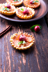 Apple caramel little tarts on brown rustic background. French tatin with paradise apple.