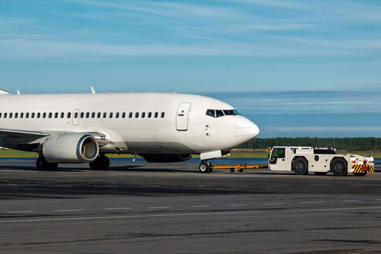 The tractor is towing the passenger airplane - Powered by Adobe