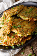 Zucchini Fritters with green onion on a plate close-up. vertical