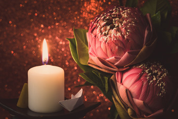 Vintage image style on pink  water lily or lotus flower folding thai style with white candle light ...
