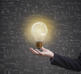 lightbulb brainstorming creative idea math formula on business hand.