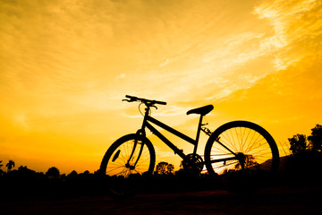 Fototapeta na wymiar bicycle silhouette with orange sky in evening for sport abstract background.