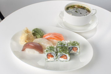 Sushi and soup on white table