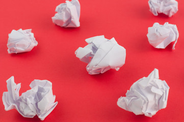 Many white crumpled papers on red paper background