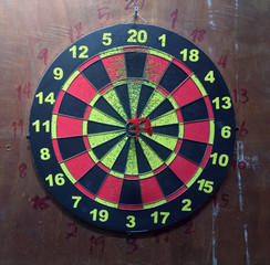 Three red darts in the center of the target, local private dart board.