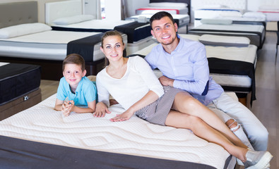 positive family of three choosing right mattress in home furnishings store