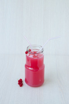 On beige background, a red currant drink