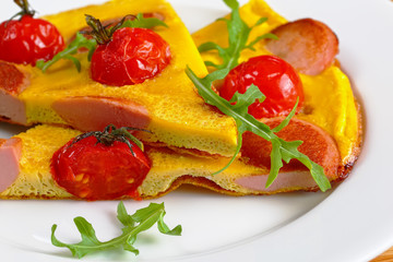 portion of tasty omelette with sausages