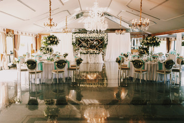 Hall decorated for wedding dinner with white cloth and roses