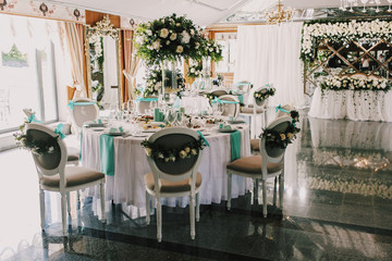 Hall decorated for wedding dinner with white cloth and roses