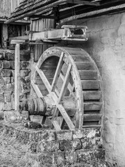 Fototapeta na wymiar Old mill water wheel without water, black and white image.