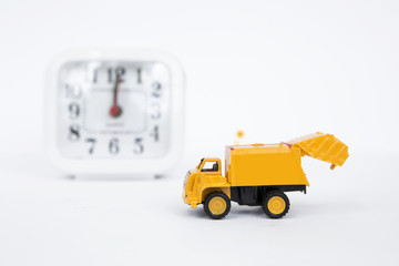 Yellow truck with blurred clock on background, on time business concept